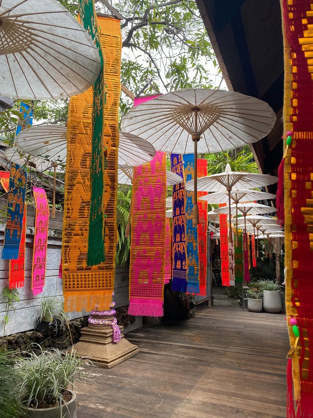 Colorful outdoor crafts market with large parasols and woven textile banners